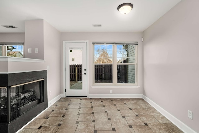 interior space featuring a fireplace, visible vents, and baseboards