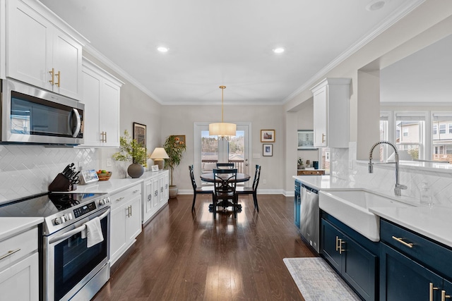 kitchen with blue cabinets, white cabinets, stainless steel appliances, and a sink