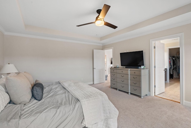 bedroom with a tray ceiling, light carpet, crown molding, and ceiling fan