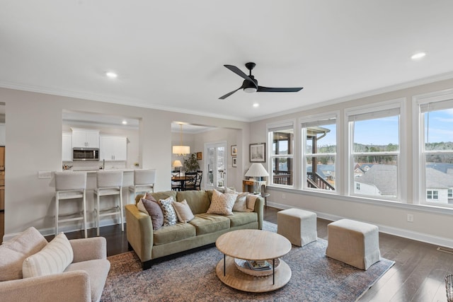 living room with crown molding, baseboards, dark wood-type flooring, and recessed lighting