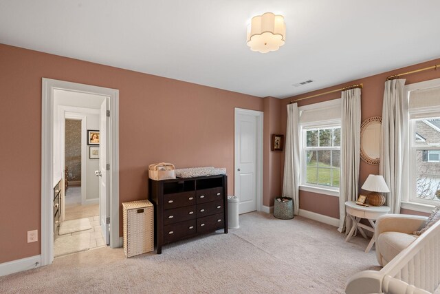 bedroom featuring visible vents, light carpet, and baseboards