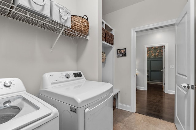 laundry room with laundry area, light tile patterned floors, baseboards, and washer and dryer