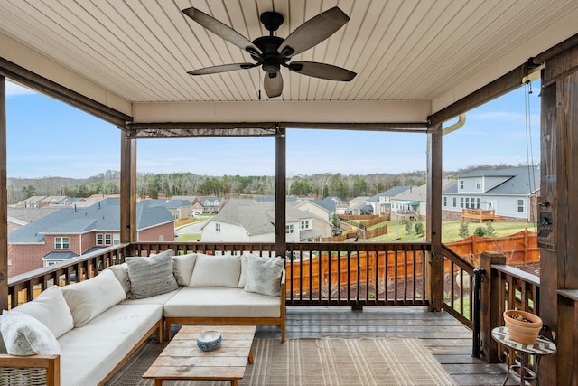 sunroom / solarium with wood ceiling, plenty of natural light, a residential view, and a ceiling fan