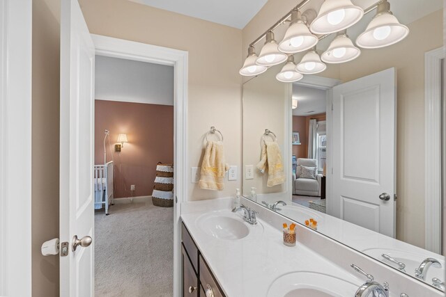 ensuite bathroom with double vanity, a sink, and connected bathroom