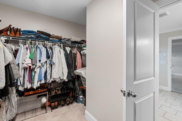 walk in closet featuring carpet floors, visible vents, and tile patterned floors