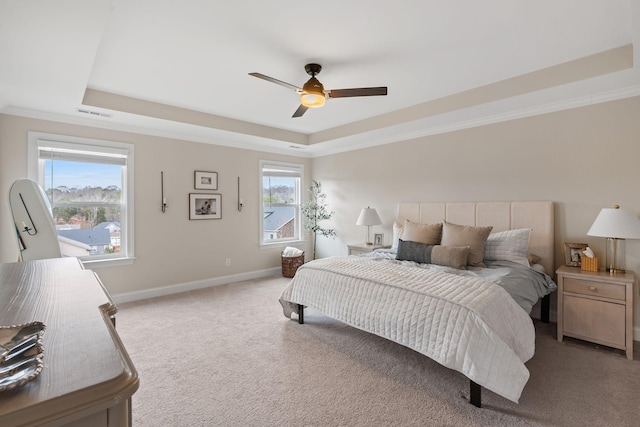 bedroom with ornamental molding, carpet floors, a tray ceiling, and baseboards