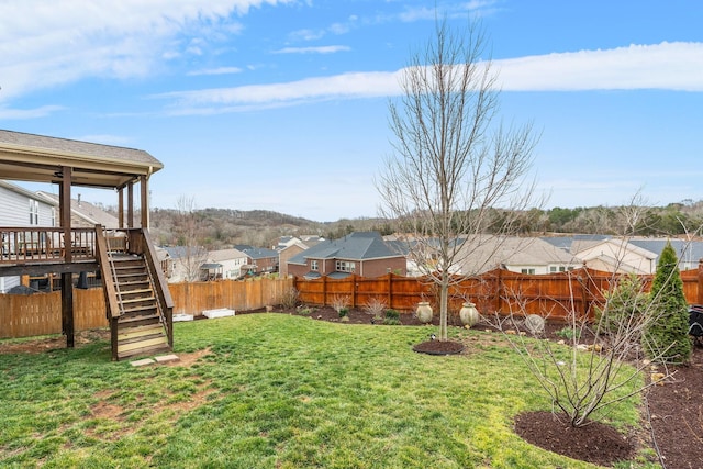 view of yard featuring stairway, a residential view, a fenced backyard, and a wooden deck