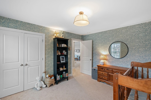 carpeted bedroom featuring wallpapered walls and a closet