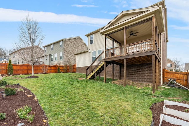 back of property featuring a ceiling fan, a lawn, a fenced backyard, stairway, and a deck