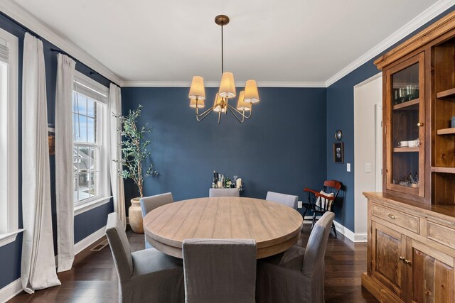 dining room with crown molding, dark wood finished floors, baseboards, and an inviting chandelier