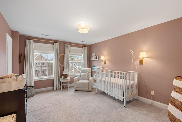 carpeted bedroom featuring a crib, visible vents, and baseboards