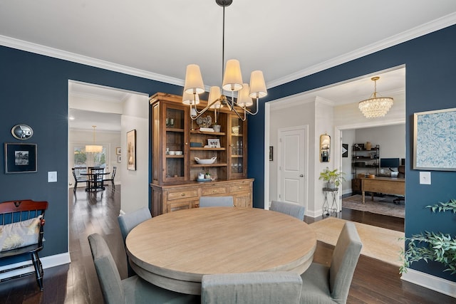 dining space featuring dark wood-type flooring, crown molding, a notable chandelier, and baseboards