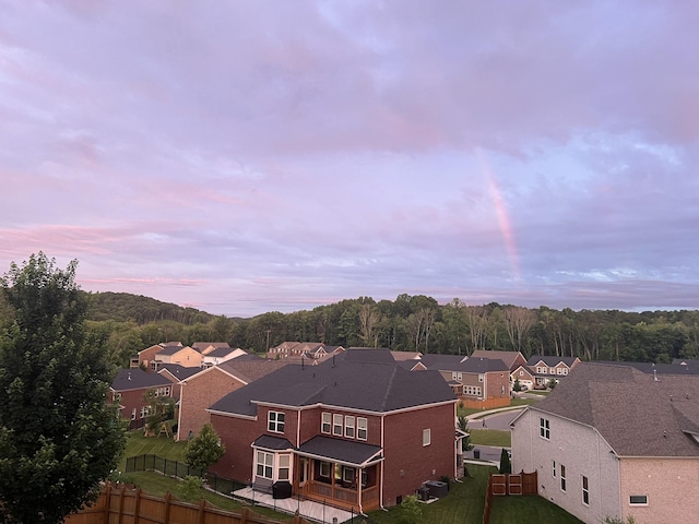 aerial view at dusk featuring a residential view and a view of trees