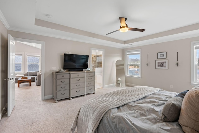 bedroom featuring a tray ceiling, light carpet, baseboards, and multiple windows