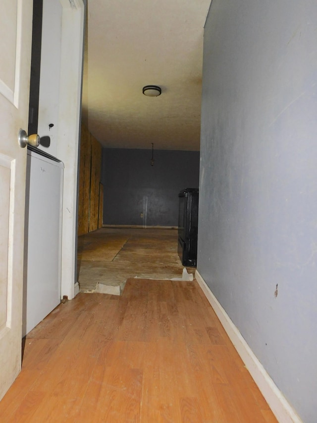 hall with baseboards and wood finished floors