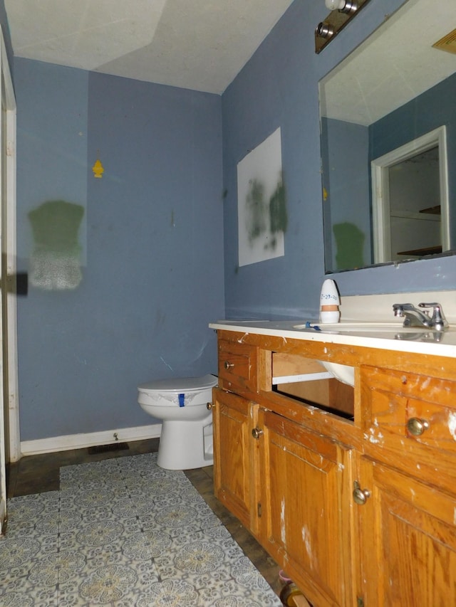 bathroom featuring wood finished floors, vanity, toilet, and baseboards