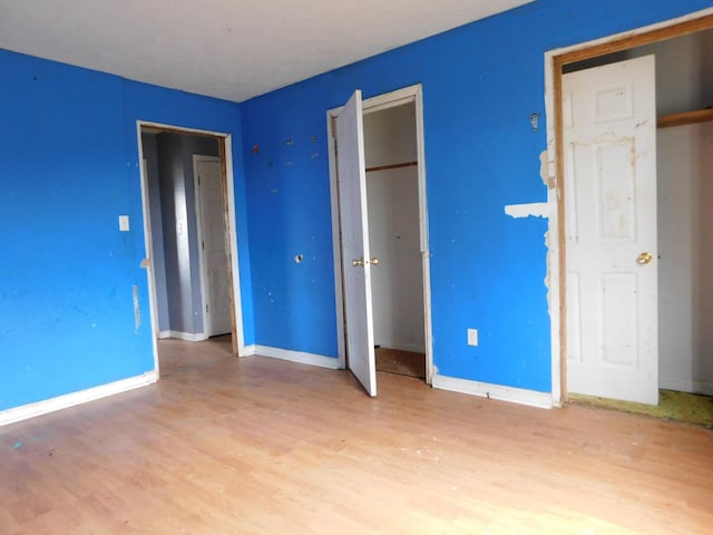 unfurnished bedroom featuring wood finished floors and baseboards