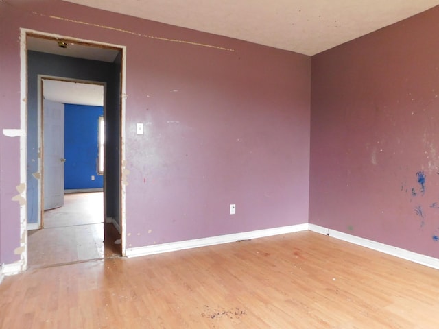 empty room with baseboards and light wood-style floors