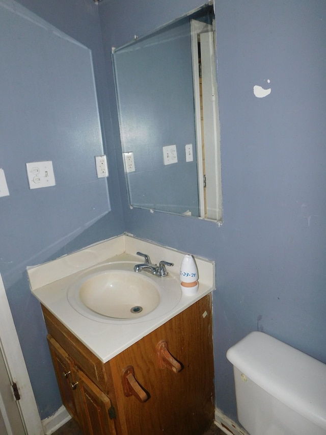 half bathroom with vanity and toilet