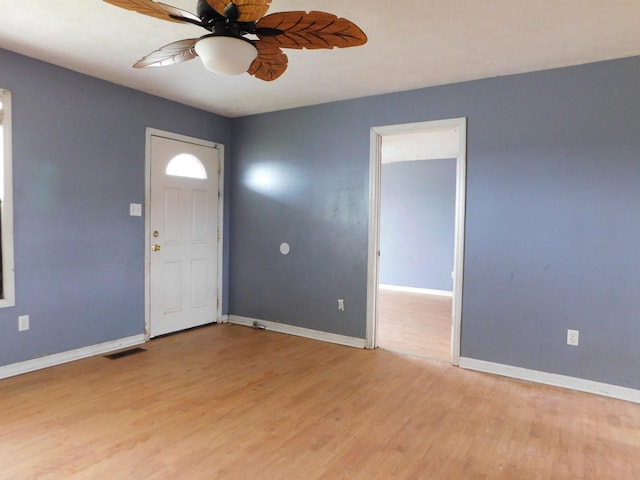 foyer entrance featuring light wood finished floors, ceiling fan, and baseboards