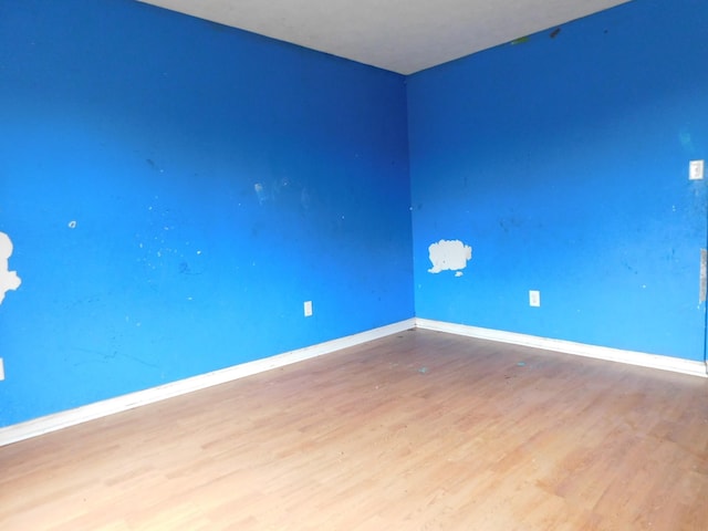 spare room featuring wood finished floors and baseboards