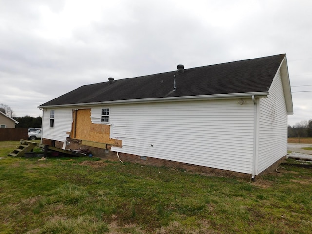 back of house featuring crawl space, a shingled roof, and a lawn