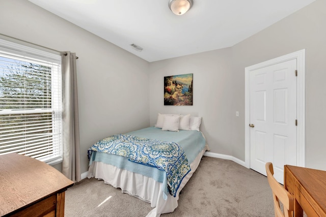 bedroom featuring baseboards, visible vents, and light colored carpet