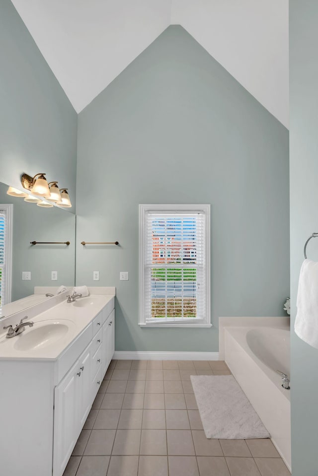 bathroom with baseboards, tile patterned flooring, high vaulted ceiling, and a sink