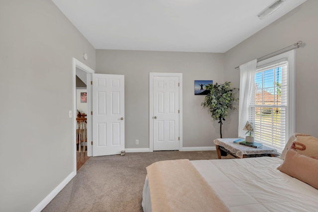 bedroom with carpet floors, visible vents, and baseboards