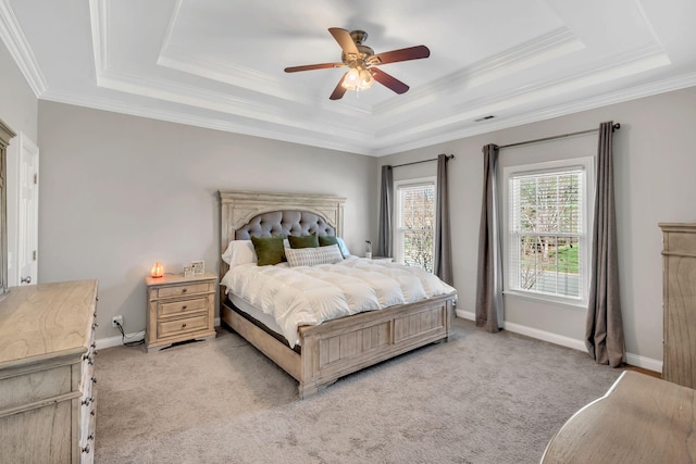 bedroom with a tray ceiling, light carpet, crown molding, and baseboards