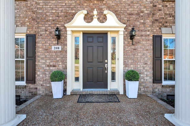 view of exterior entry featuring crawl space and brick siding