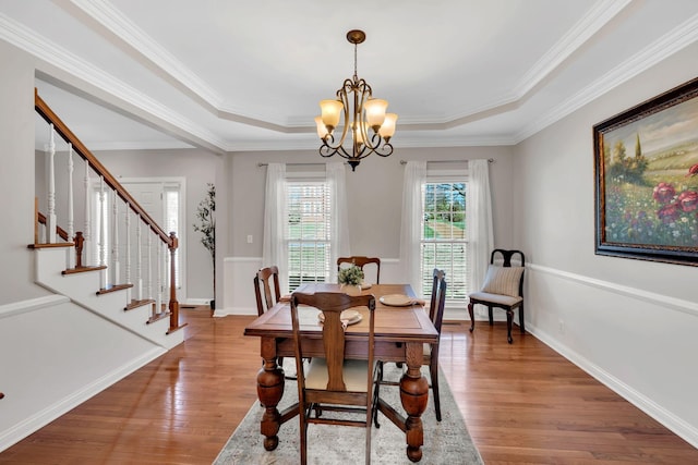 dining area featuring a chandelier, baseboards, and wood finished floors
