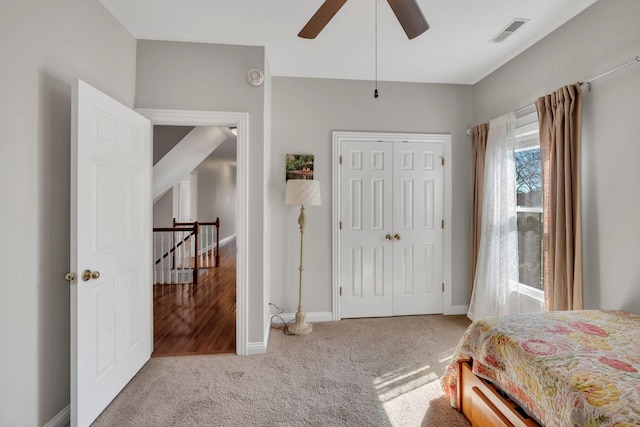 bedroom with carpet flooring, a ceiling fan, visible vents, baseboards, and a closet