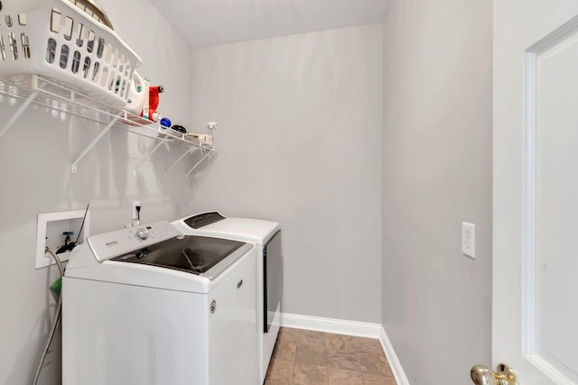 clothes washing area featuring laundry area, baseboards, and separate washer and dryer