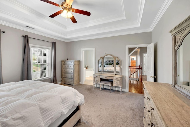 bedroom featuring a raised ceiling, light carpet, and crown molding