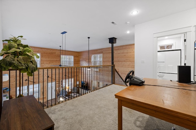 carpeted office featuring recessed lighting, visible vents, and wood walls