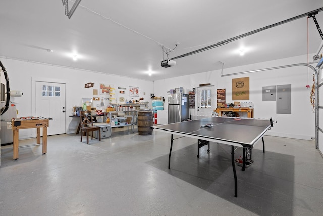 recreation room featuring a garage, a workshop area, and electric panel