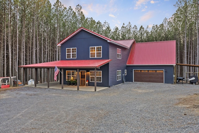 view of front facade featuring a garage, metal roof, and driveway