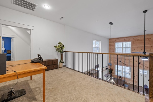 carpeted office featuring wood walls and visible vents