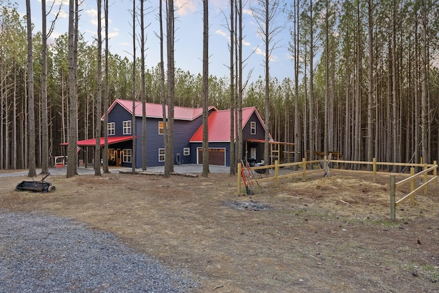 view of jungle gym featuring a forest view and fence