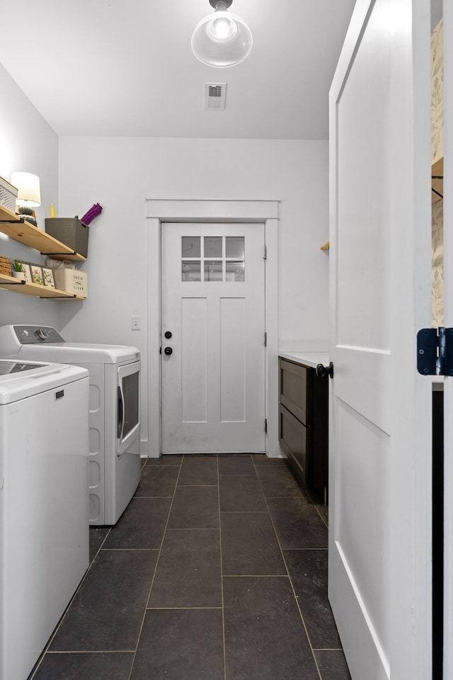 laundry area featuring laundry area, dark tile patterned floors, independent washer and dryer, and visible vents