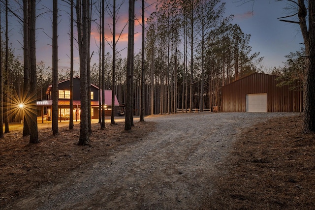 view of front of house featuring dirt driveway and an outbuilding