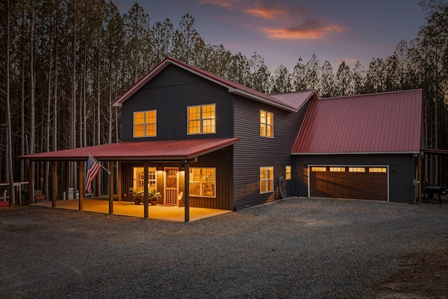 view of front of house with gravel driveway and metal roof