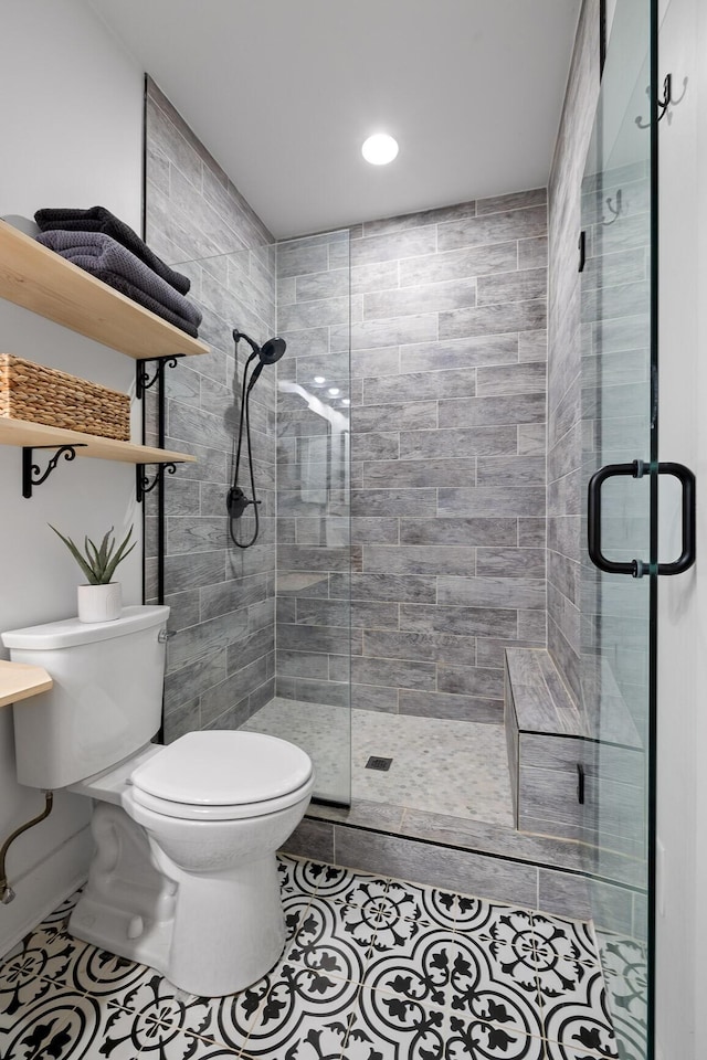 full bath featuring toilet, a shower stall, and tile patterned floors