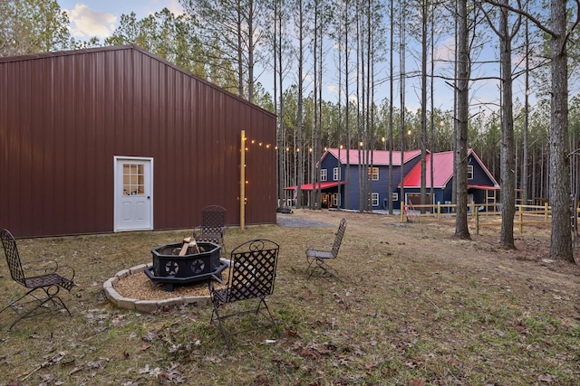 view of yard featuring a fire pit and an outbuilding