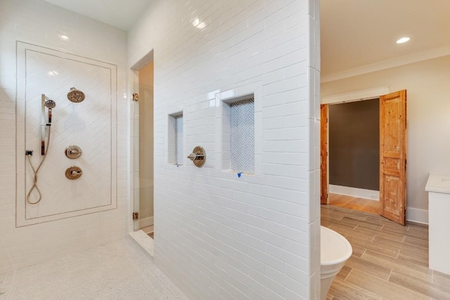 bathroom with baseboards, wood tiled floor, a tile shower, a soaking tub, and vanity