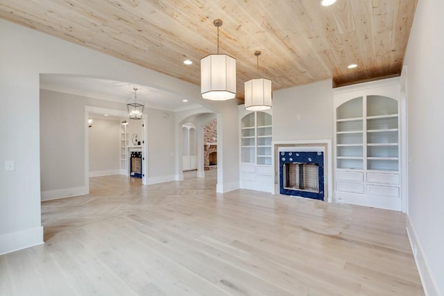 unfurnished living room featuring built in features, baseboards, a fireplace, recessed lighting, and wood ceiling