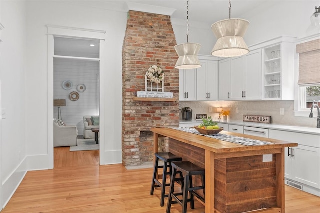 kitchen featuring open shelves, butcher block countertops, white cabinets, and light wood-style floors