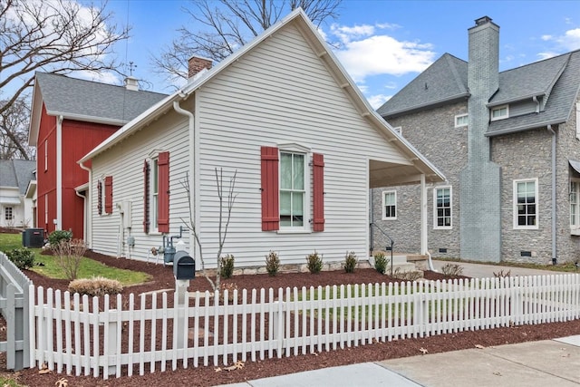 view of front of home featuring crawl space, a fenced front yard, a chimney, and cooling unit