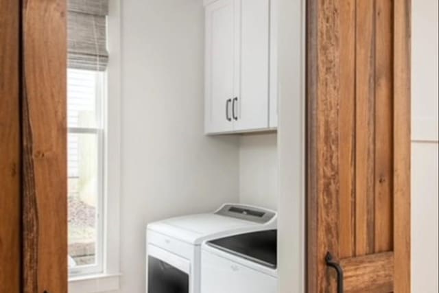 clothes washing area with cabinet space and independent washer and dryer